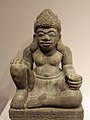 This seated figure may be a dharmapala. The pedestal below (not pictured) features an image of a kala head.
