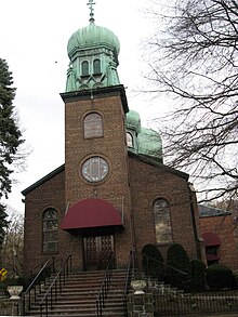 A brown brick church with a weathered, onion-shaped dome
