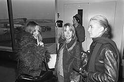 Three young women, with a fourth in the background