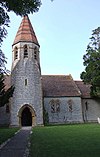 Stone building with square tower which becomes hexagonal near the roof.