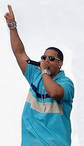 A man wearing blue T-shirt and dark glasses is performing