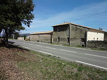 View from the grass verge of the main N96 road, showing the rear of the Dominicis' farm, "La Grand' Terre", abutting the other side of the road.