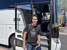 Boy stands in front of a bus