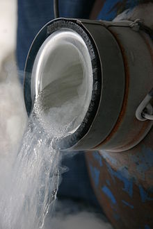 A transparent liquid, with visible evaporation, being poured