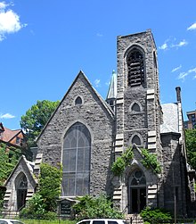 Exterior of a gray stone church against a blue sky