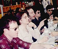 Five men sitting at a table at a press conference
