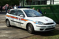 White hatchback with red and amber horizontal stripe along the midline and 'Surrey Police' lettering below the stripe