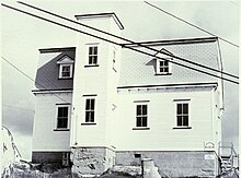 A two-storey courthouse building, with a flat-topped front tower slightly offset to the left of the building. The building has a mansard roof with peaked dormer windows.