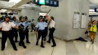警员手持警棍后退和离开港铁站