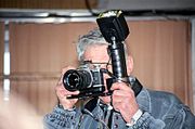A photographer hands Pentax MZ-5n with Metz flashlight