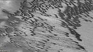 背景相机观测到的2014年末沙尘暴后的布拉希尔陨击坑沙丘和尘暴痕迹。