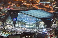 Night aerial shot of large angular modern building lit from within