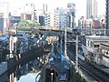 列车行经秋叶原电气街及神田川的高架路段（松住町架道桥（日语：松住町架道橋）、神田川桥梁（日语：神田川橋梁 (総武本線)））。摄于2014年12月19日。