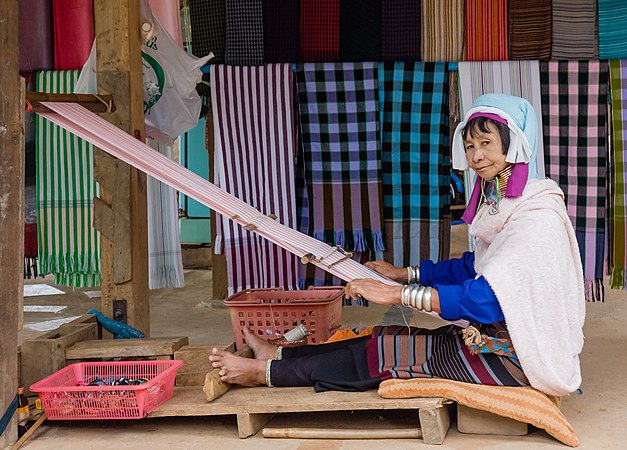 颈部配带铜圈的巴东族妇女正在使用织布机。摄于缅甸大其力。