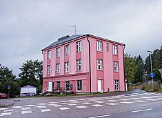 A pink building at Vesijärventie in Vääksy, the oldest apartment building of village. Previously served as a guest house and as residence. Today as a ’French-style village shop’.