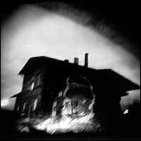 A slightly blurred black and white photograph of a house.