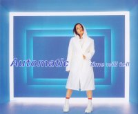 A body shot of a Japanese–American woman (Hikaru Utada) standing in front of a blue room, surrounded by led-lights. She is wearing white clothing and has her name and the song's title superimposed.