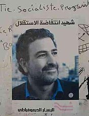 A poster displaying the face of Samir Kassir and containing Arabic text, the DLM logo, and some sharpie scribbles