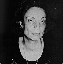 Portrait of a woman wearing a dark scoop necked blouse
