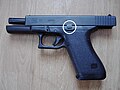 Slide stop in its "up" position, locking the slide of this Glock pistol in its "back" position. Pressing down the switch releases the slide to spring forward.