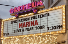A color photograph of a marquee sign displaying "Live Nation Presents 'Marina' Love & Fear Tour, 7:30 PM".