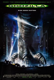 A giant reptilian foot, against a cityscape, lit up by searchlights.