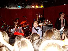 Jack's Mannequin performs onstage with Andrew McMahon playing piano and singing into a microphone