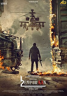 Mohanlal faces a Boeing AH-64 Apache chopper in a war zone, armed with an assault rifle, as an armored truck is ablaze on both sides