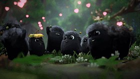 A small, black, furry creature appears in the centre of the screen, surrounded by other identical-looking creatures who dance and cheer.