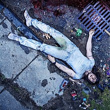 Rock musician Andrew W.K. lying on the ground amidst broken bottles