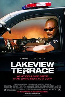 A bald police officer with sunglasses in a car looks toward the viewer. Below him shows the actor who plays him, the title, statement, production credits and release date.