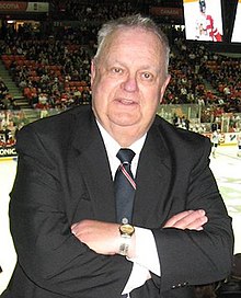 Johnson standing in the press box at a hockey game