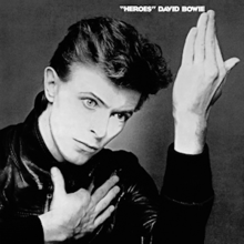 A black and white photograph of Bowie's face with his hands held up