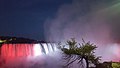 A view of Horse Shoe Falls with the Canadian flag at night time.