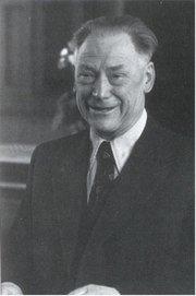 Head and a torso of a smiling bolding man in his fifties, dressed in a dinner suit