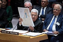 Photograph of Abbas holding a map of the Trump plan