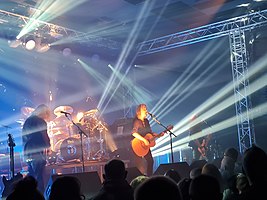 New Model Army performing in 2022, left to right: Dean White (keyboards and guitar), Michael Dean (drums), Justin Sullivan (vocals and guitar), Ceri Monger (bass).