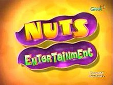 An image of an opened nut, over an orange glossy background. The show title is displayed on the center of the image. The logo of GMA Network is displayed on the upper right side of the image.