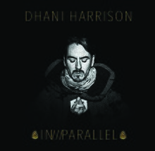 A black-haired, Caucasian man's face on a black background. All text on the cover is gold. Above his head are the words "DHANI HARRISON", and below reads "IN///PARALLEL", surrounded by what appear to be two pine cones.