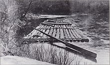 一只用长圆木绑在一起的木筏，上面绑着一把大桨，用来掌舵。